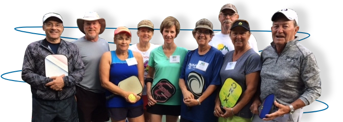 group photo while holding pickleball paddles