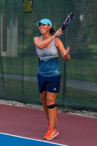 Woman playing tennis with a racket.
